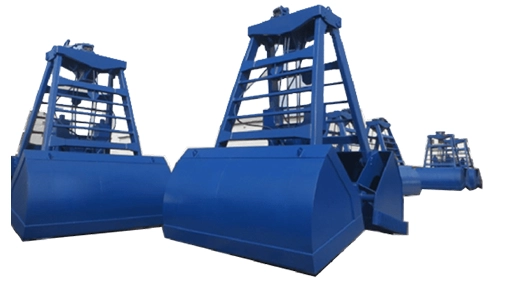 Rapidpack clamshell grabs lined up outdoors, heavy-duty hydraulic grips open above surface
