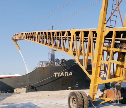 Rapidpack shiploader alongside loader vehicle, operating at high-speed bulk loading port environment